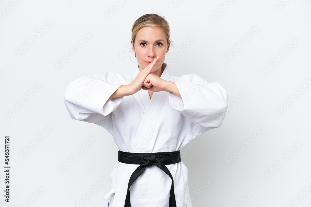 Young caucasian woman isolated on white background doing karate and saluting Young caucasian woman isolated on white background doing karate and saluting