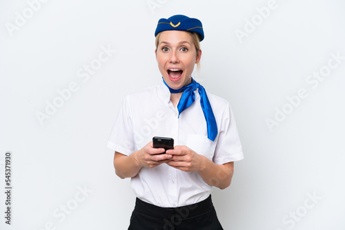 Airplane blonde stewardess woman isolated on white background surprised and sending a message © luismolinero