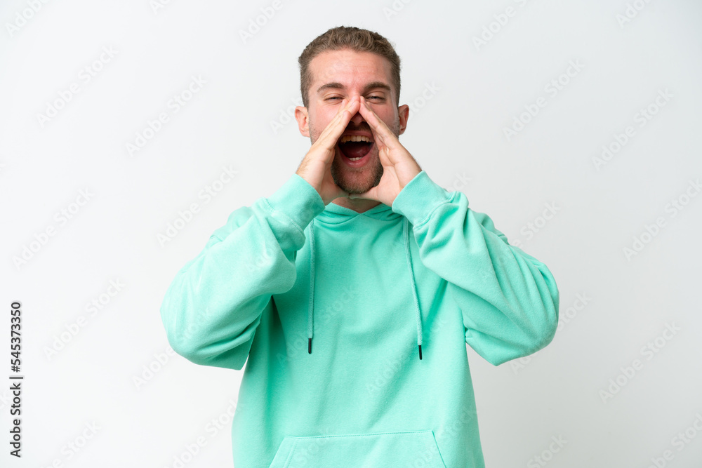 Young handsome caucasian man isolated on white background shouting and announcing something Young handsome caucasian man isolated on white background shouting and announcing something