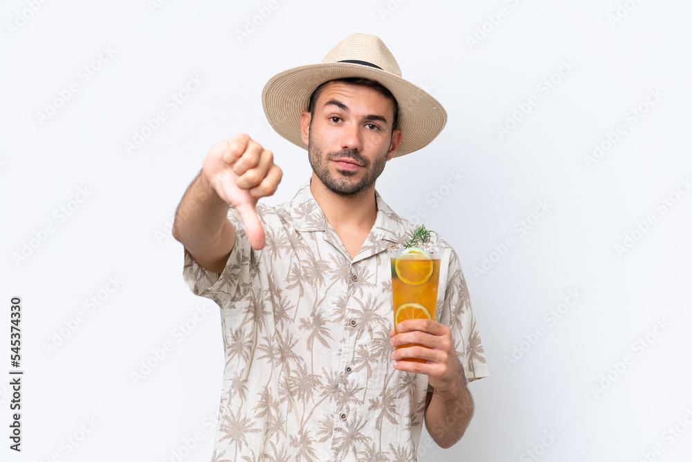 Young caucasian man holding a cocktail isolated on white background showing thumb down with negative expression Young caucasian man holding a cocktail isolated on white background showing thumb down with negative expression