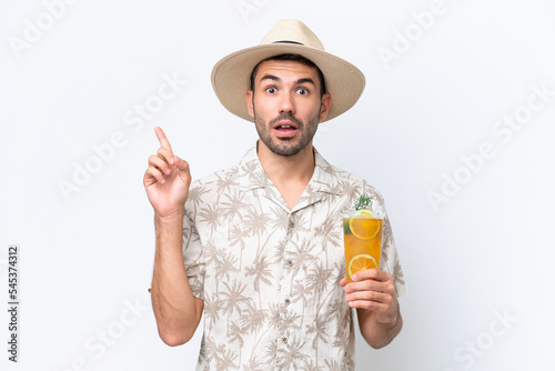 Young caucasian man holding a cocktail isolated on white background thinking an idea pointing the finger up