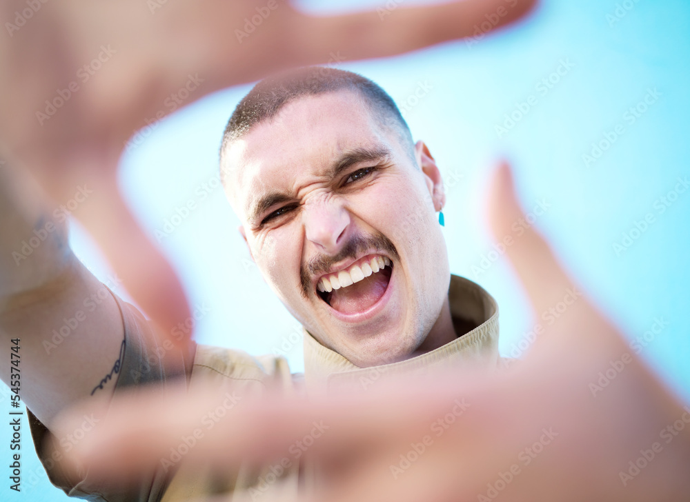 Obraz premium Face hands frame, smile and man portrait feeling happy about beauty, fashion and skincare. Smile, comedy and silly gen z model with a aesthetic hand sign feeling happiness, creativity and funny