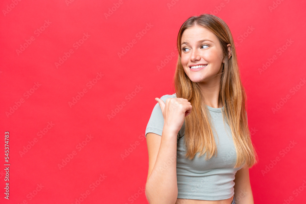 Young beautiful woman isolated on red background pointing to the side to present a product Young beautiful woman isolated on red background pointing to the side to present a product