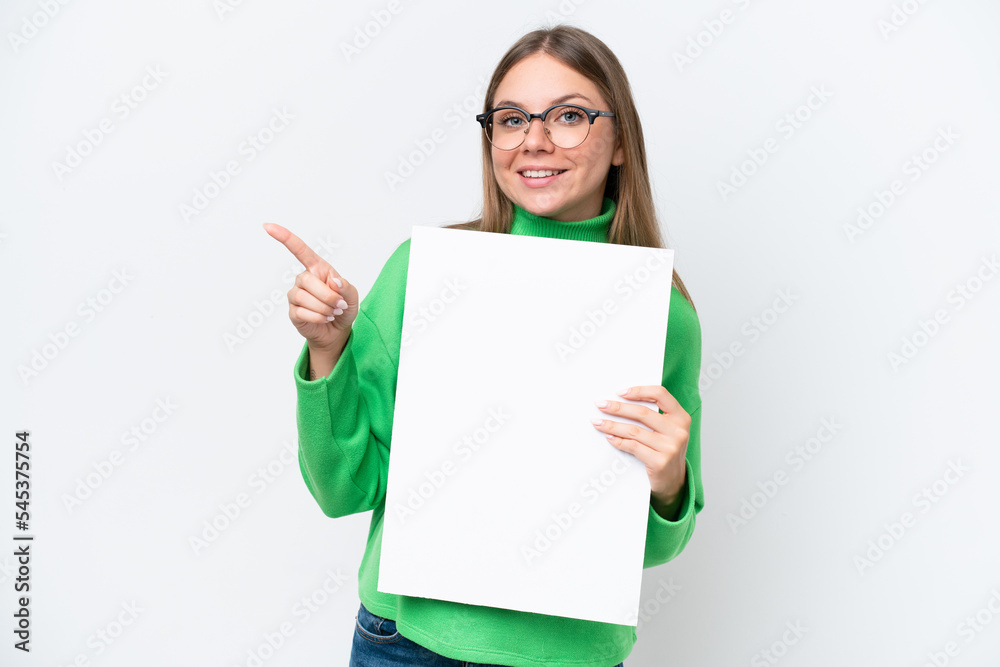 Young caucasian woman isolated on white background holding an empty placard and pointing side Young caucasian woman isolated on white background holding an empty placard and pointing side