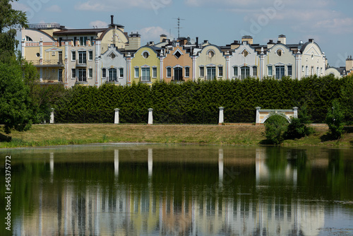 View of colored apartment houses near a pond on a private territory