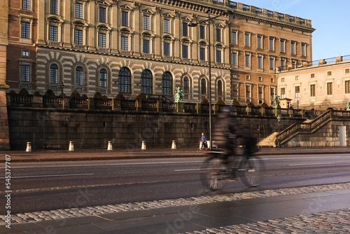 Photography Commuter cyclists biking in bike lane in front of Stockholm Royal Palace an autu
