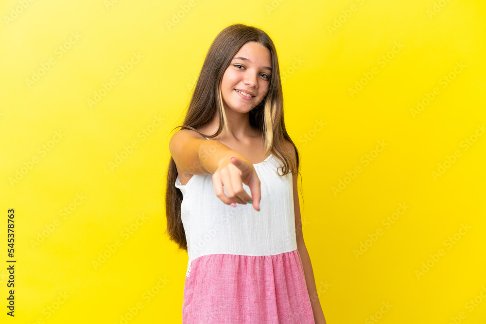 Little caucasian girl isolated on yellow background pointing front with happy expression Little caucasian girl isolated on yellow background pointing front with happy expression