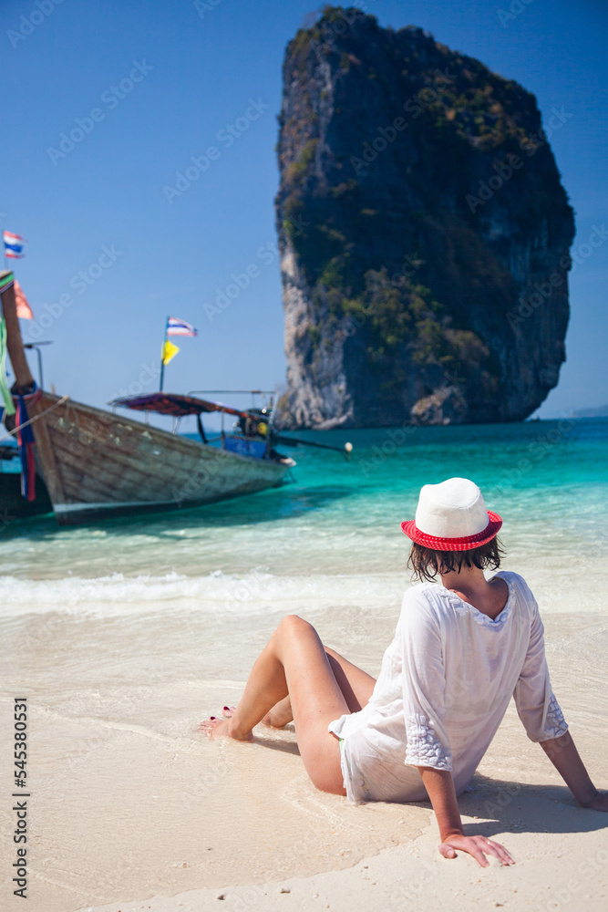 woman on beautiful tropical beach in Thailand with longtail boats woman on beautiful tropical beach in Thailand with longtail boats