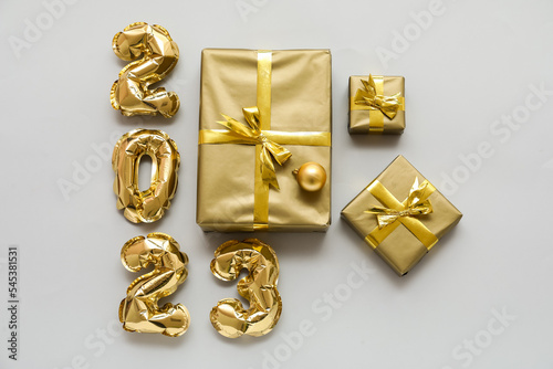 Beautiful Christmas gifts and figure 2023 made of balloons on light background