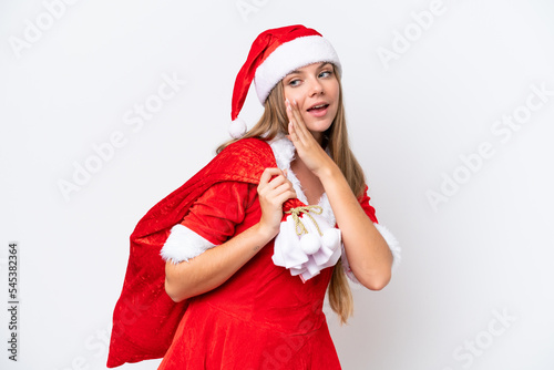 Young caucasian woman dressed as mama noel holding Christmas sack isolated on white background whispering something