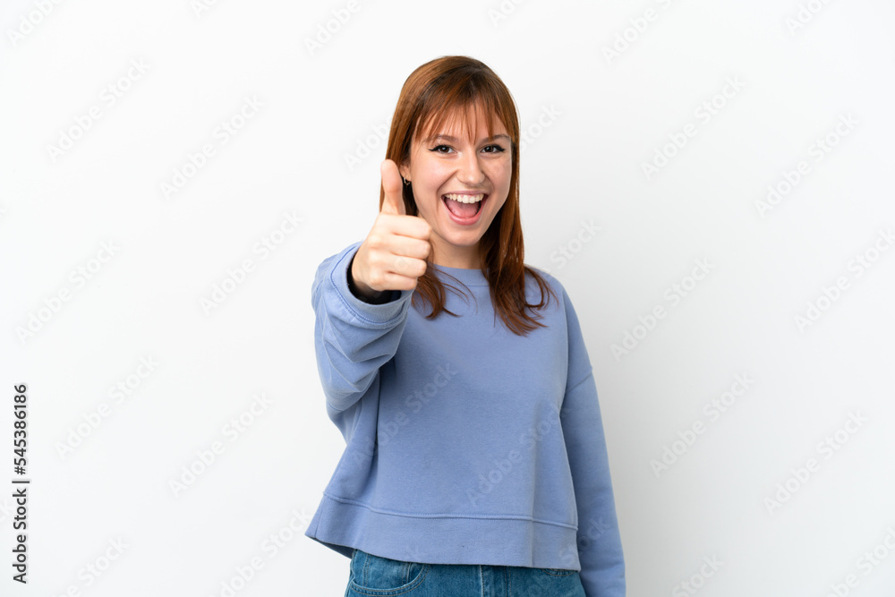 Redhead girl isolated on white background with thumbs up because something good has happened Redhead girl isolated on white background with thumbs up because something good has happened