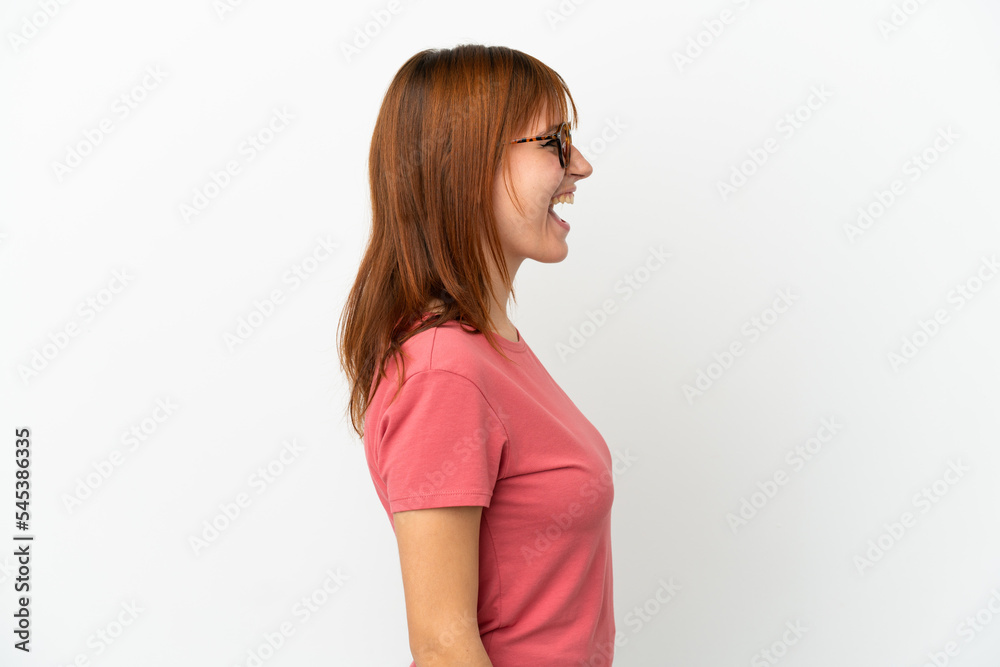 Redhead girl isolated on white background laughing in lateral position Redhead girl isolated on white background laughing in lateral position