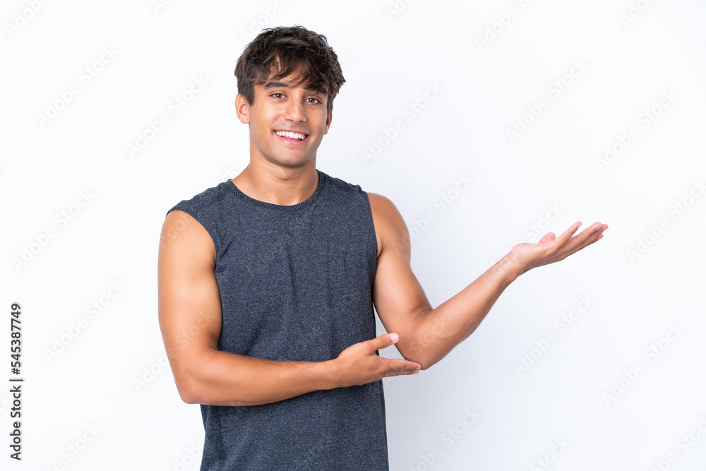 Young sport caucasian man isolated on white background extending hands to the side for inviting to come Young sport caucasian man isolated on white background extending hands to the side for inviting to come