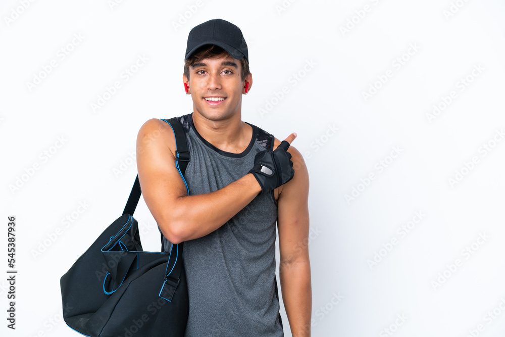 Young sport caucasian man with sport bag isolated on white background pointing to the side to present a product Young sport caucasian man with sport bag isolated on white background pointing to the side to present a product