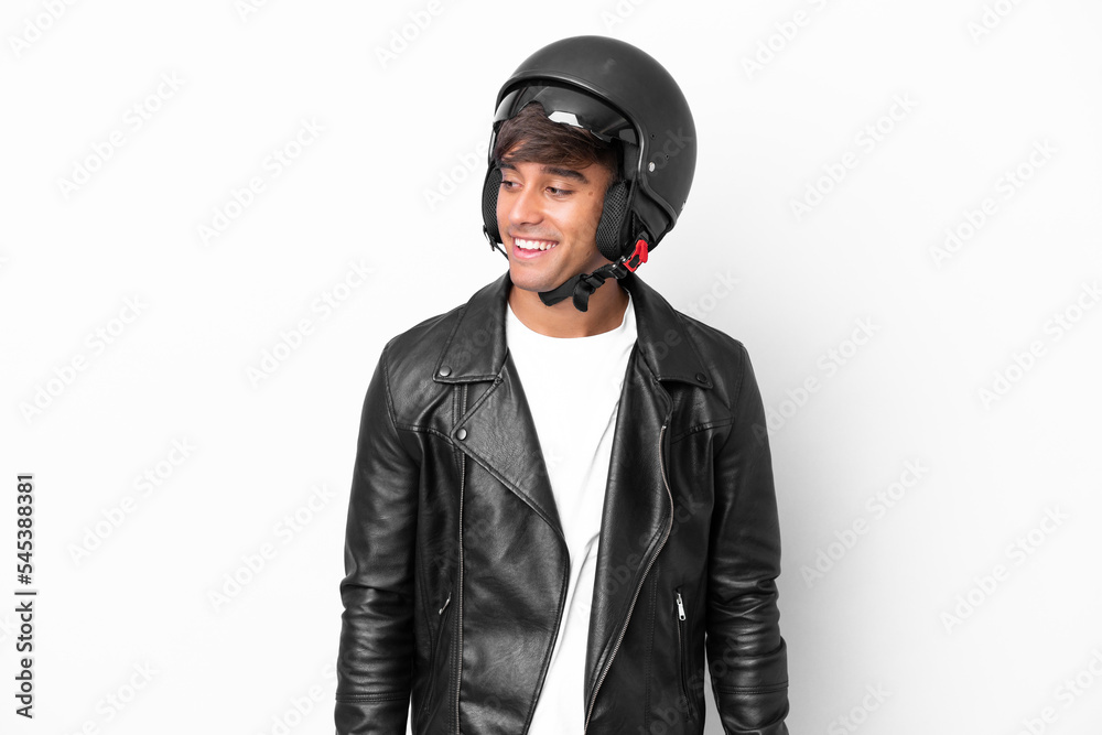 Young man with a motorcycle helmet isolated on white background looking to the side and smiling Young man with a motorcycle helmet isolated on white background looking to the side and smiling