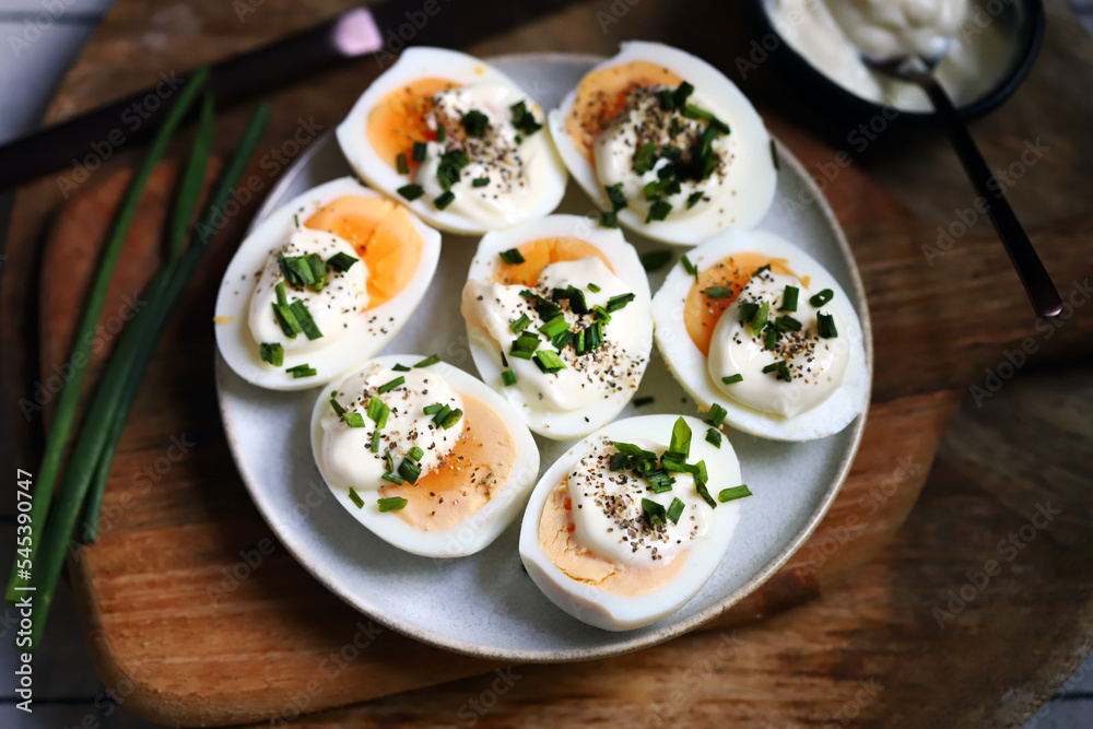 Boiled egg halves with mayonnaise and green onions.