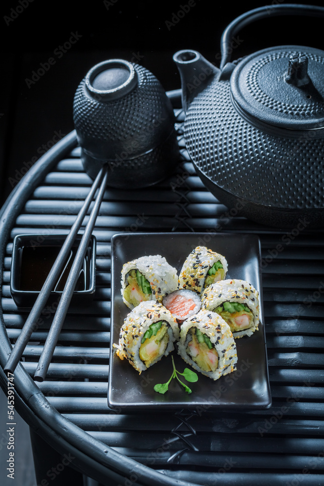 Tasty and fresh sushi set served on black slate stone.