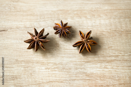 Three stars of star anise on a wooden background. The concept of the New Year and Christmas time. Holiday atmosphere