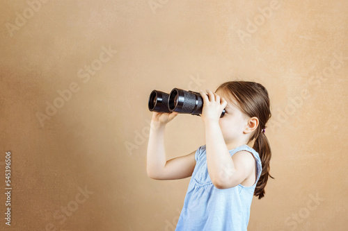 Happy child looking ahead through binoculars. Smiling child with binoculars. Travel and adventure concept. Freedom, rest