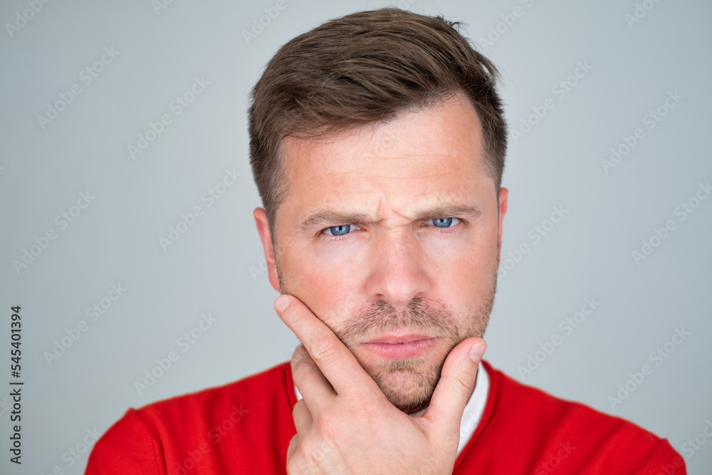 Portrait of pensive mature man touching chin making decision. 