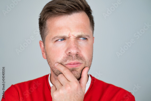 Portrait of pensive mature man touching chin making decision. 