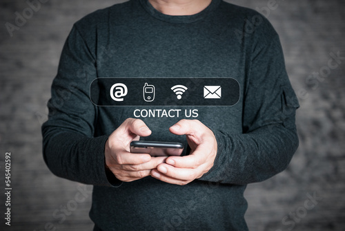 Businessman using smartphone and touch on virtual screen contact icons(address,phone,wifi,email),Contact us and Customer support hotline people connect.