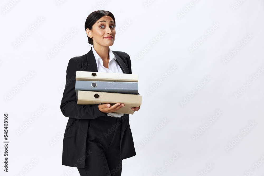 Business woman with a folder of documents in her hands in a black business suit and glasses shows signals gestures and emotions on a white background, work freelancer online training Business woman with a folder of documents in her hands in a black business suit and glasses shows signals gestures and emotions on a white background, work freelancer online training