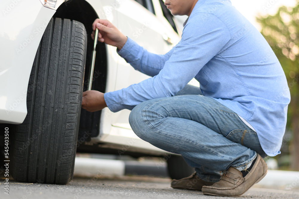 The driver checks the tire pressure. The driver checks the tire pressure.