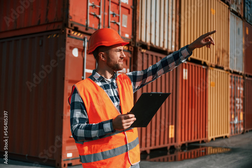 Digital tablet in hands. Male worker is on the location with containers