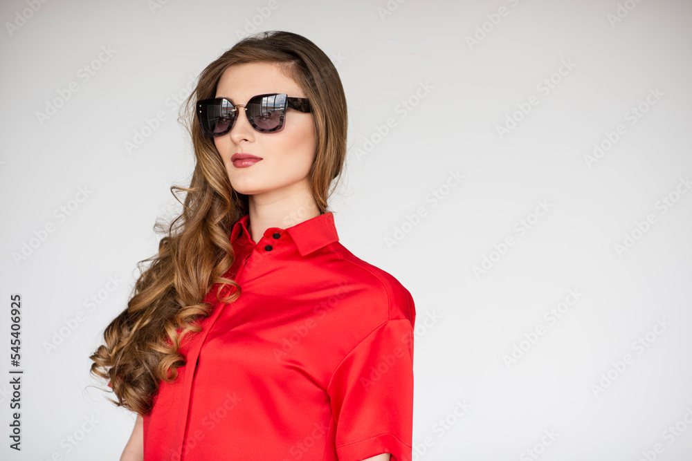 Profile portrait of a attractive young woman wearing glasses and red shirt, isolated white background.