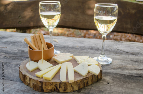 Goat cheese and white wine sampler served on a wooden board. photo