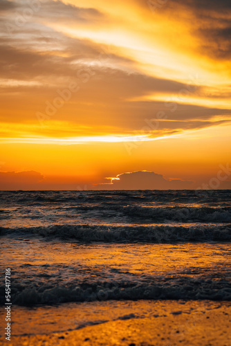 silhouette of the beach during golden sunset. © ellinnur