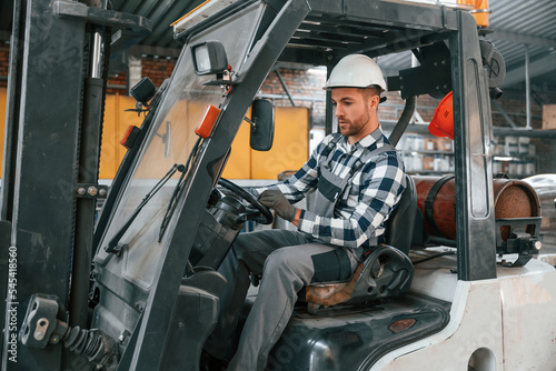 Forklift driver. Factory male worker in uniform is indoors