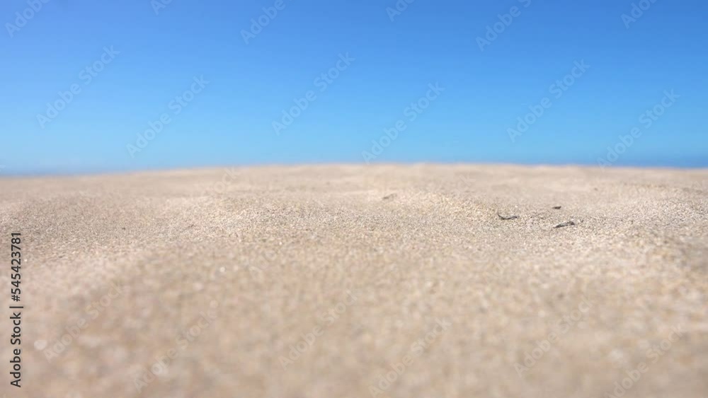 Close-up of grains of sand blowing in the wind on a bright sunny day at the tropical beach Close-up of grains of sand blowing in the wind on a bright sunny day at the tropical beach