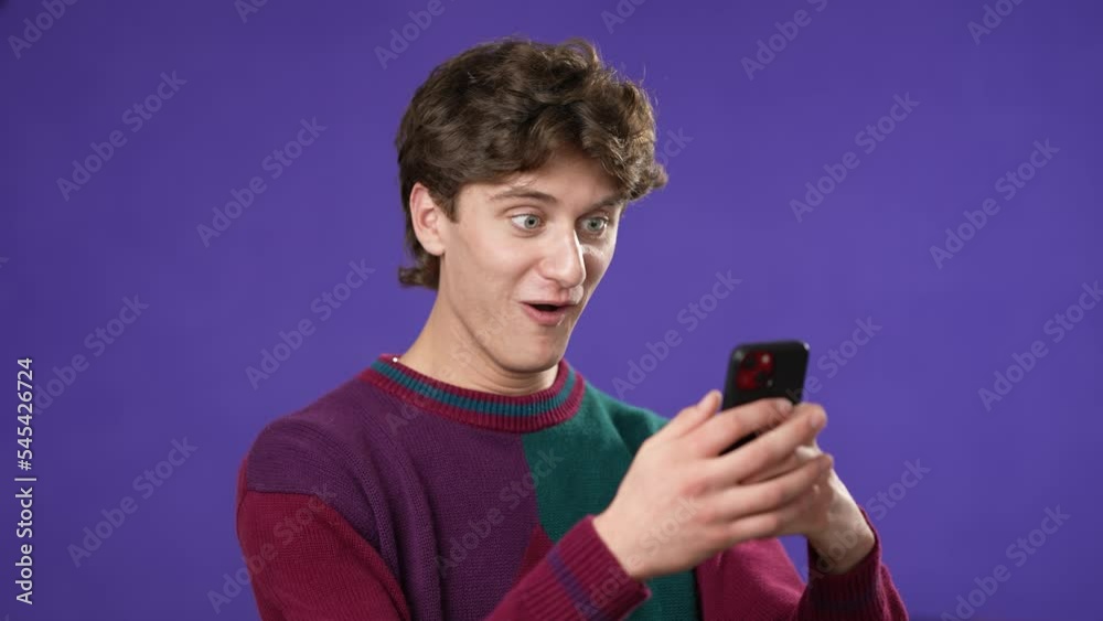 Portrait of promoter fun hold use mobile cell phone point finger give thumbs up mockup promo commercial area isolated on solid purple background Portrait of promoter fun hold use mobile cell phone point finger give thumbs up mockup promo commercial area isolated on solid purple background
