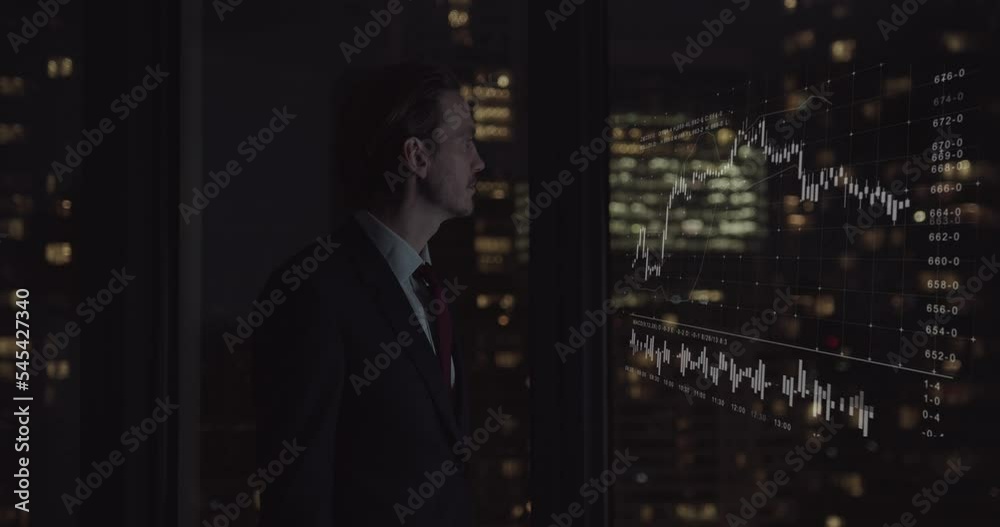 Businessman Trader Working Late in office Looking at Stock Market Data Businessman Trader Working Late in office Looking at Stock Market Data