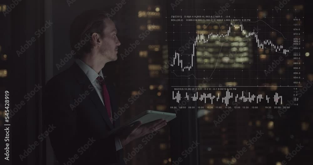 Businessman using Digital Tablet Working Late at night in Office with City Skyline Businessman using Digital Tablet Working Late at night in Office with City Skyline