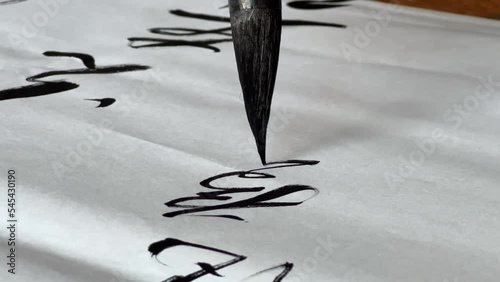 An old Chinese calligrapher is writing calligraphy characters, creating calligraphy works photo