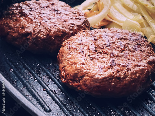 Obraz na plátně Cooking minced beef burger on cast iron grill skillet outdoors, red meat on fryi