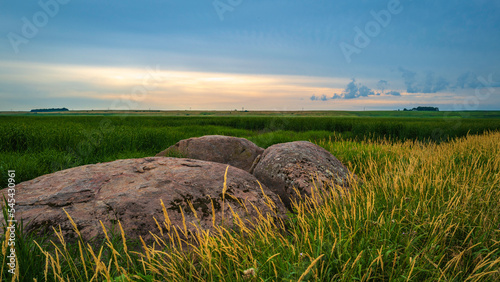 Tranquil sunset landscape over the prairie with glacial rocks in Big Stone National Wildlife Refuge in Odessa, Minnesota, USA photo