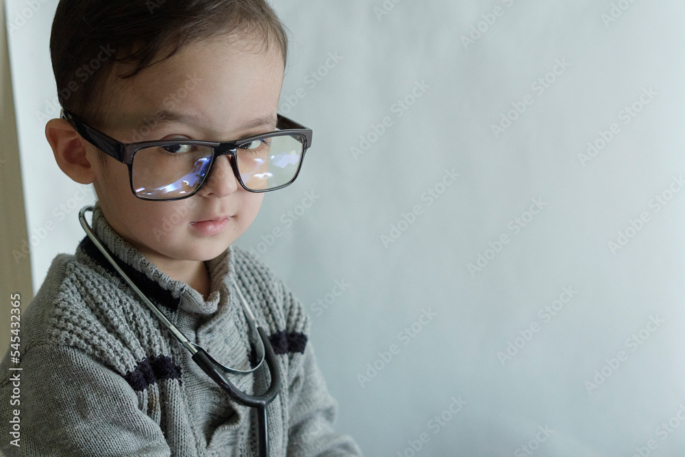 a little boy with glasses and a stel on his head, looking at the camera while he is wearing a stel a little boy with glasses and a stel on his head, looking at the camera while he is wearing a stel