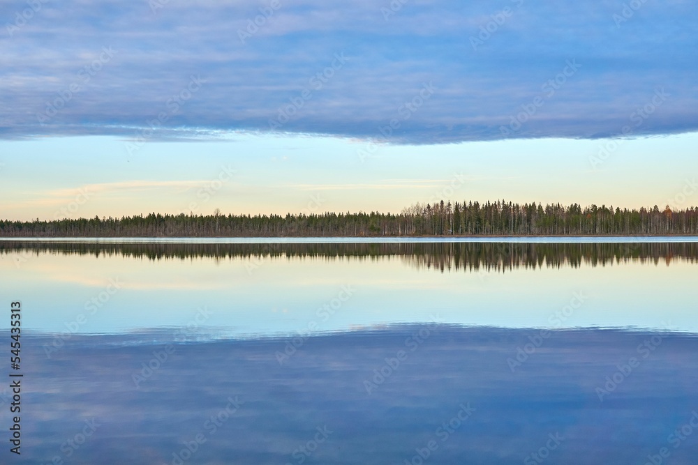 Beautiful landscape of a lake with calm waters that reflect the trees and clouds