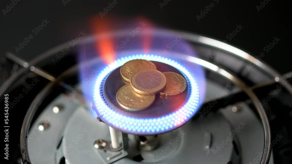 Euro coins sitting in the center of a gas burner being lit until gas runs out Euro coins sitting in the center of a gas burner being lit until gas runs out