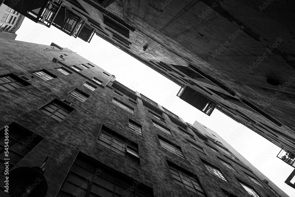 Obraz premium Low angle view of stony buildings in black and white