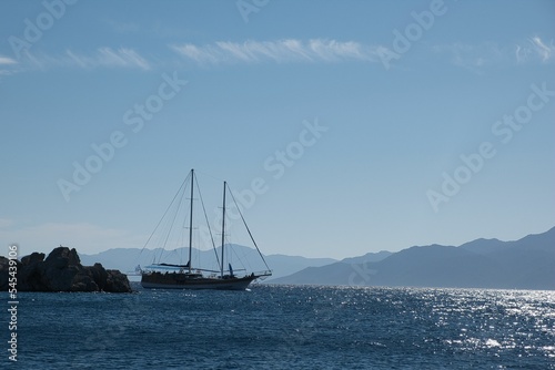 Beautiful view of a sailboat in the bay of Pedi, Symi island, Greece.