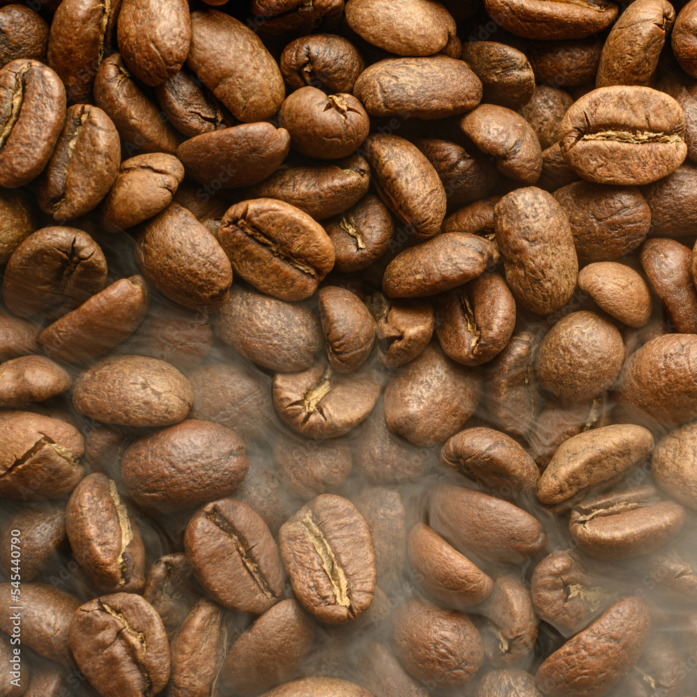 The texture of freshly roasted, ready-to-drink coffee, steam rising above the beans, black ava beans. The texture of freshly roasted, ready-to-drink coffee, steam rising above the beans, black ava beans.