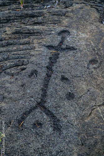 Prehistoric carving on a lava rock part of the Pu u Loa Petroglyphs along the Chain of Craters Road in the Hawaiian Volcanoes National Park on the Big Island of Hawaii in the Pacific Ocean