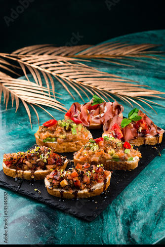 various bruschettas with toppings on marble. Snack finger food meal for wine, italian starter.