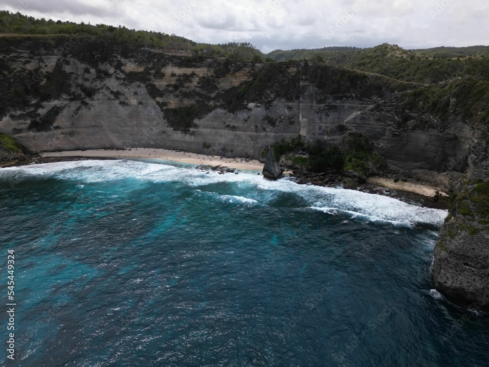 Fototapeta premium Vertical bird's eye view of a seacoast surrounded by cliffs