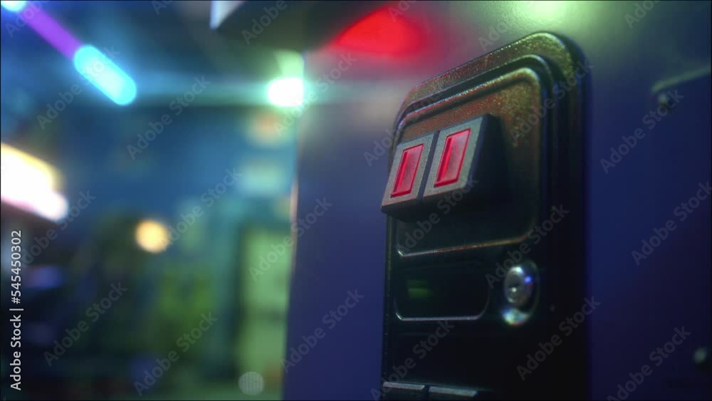 Man sliding a coin into the acceptor and playing an arcade game on the machine Man sliding a coin into the acceptor and playing an arcade game on the machine